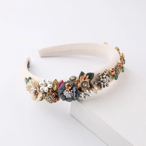 Close-up of handmade floral headband with padded fabric, faux pearls, and crystals
