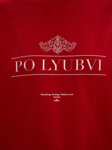 Detail view of the white graphic print on a red 100% cotton short-sleeve T-shirt