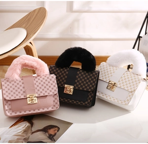 Detail of plush faux fur handles and gold metal locks on printed crossbody bags