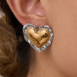 Close-up of dual-tone heart earrings with gold center and hammered silver edges