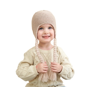 Chic knit baby hat with long braid tassels and matching cable knit sweater set in beige