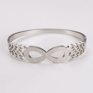 Macro detail of silver infinity symbol with frosted texture and hollow Celtic knot patterns