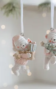 Detailed macro view of white resin Christmas bear ornament with pink hat and gift box