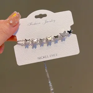 Silver butterfly adjustable bracelet with shell and black accents on display card