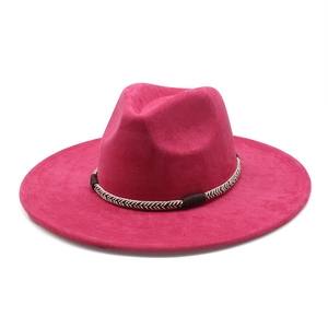 Close-up of a rose pink suede fedora hat with a woven black and white decorative band