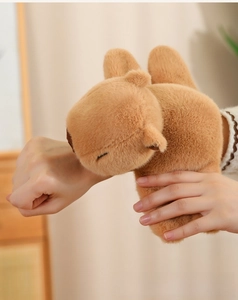 Close-up of a soft brown capybara plush slap bracelet worn on a person's wrist
