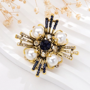 Detailed view of vintage gold brooch with white pearls and deep blue gemstones