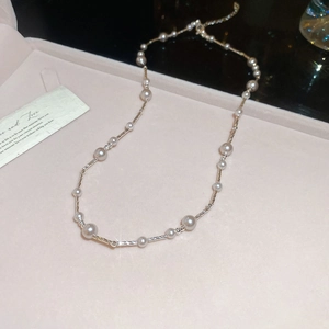 Detail of elegant pearl necklace with silver chain inside a pink jewelry gift box