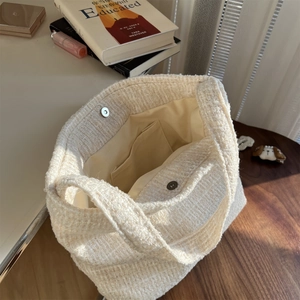 Détail du sac en tweed tissé montrant la poche interne et les fermoirs magnétiques