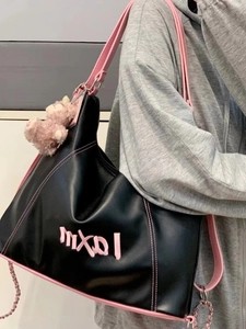 Large black contrast pink tote bag with bear charm shown from a side view on model
