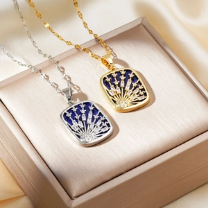 Close-up of gold and silver meteor pendant necklaces on a champagne silk jewelry box