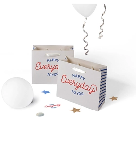 Detail of white paper gift bag with blue stripes and elegant white satin ribbon handles