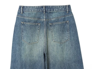 Close-up of high-quality denim back pockets and stitching on blue distressed jeans