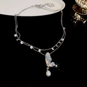 Dettaglio della collana a doppio strato con farfalla, cristalli blu e perla