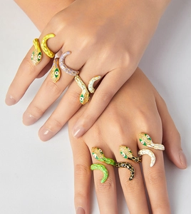 Detail of hand-worn colorful enamel snake rings with gold plating and cubic zirconia