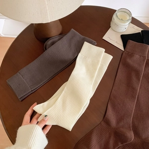 Detailed view of ribbed knit cotton socks in various earthy tones on a rustic wooden table