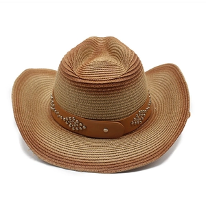 Close-up of leather band with silver studs on a woven straw cowboy hat detail