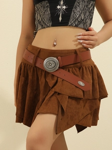 Detail of suede layered mini skirt with a vintage western-style engraved buckle belt