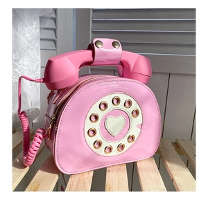 Detail view of pink vintage telephone bag with rotary dial and heart-shaped center