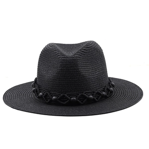 Detailed close-up of woven black straw fedora with decorative beaded band