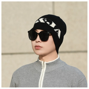 Detail of black rib-knit beanie with white jacquard letters for winter outdoor style