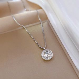 Gros plan du collier en acier titane argenté avec pendentif circulaire serti de cristaux