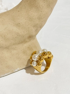 Artistic close-up of a vintage gold wide ring featuring layered pearls and gold beads
