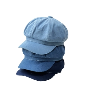 British style denim newsboy caps in light, medium, and dark blue wash stacked on white