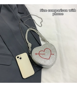 Dettaglio borsa a cuore argento con freccia di strass rossi e riferimento dimensionale