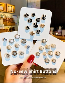 Close-up of assorted pearl and enamel decorative pins on a white display card
