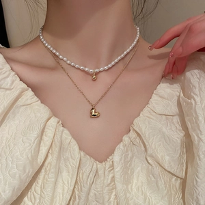 Double-layered gold necklace with heart pendant and delicate white pearls set for women