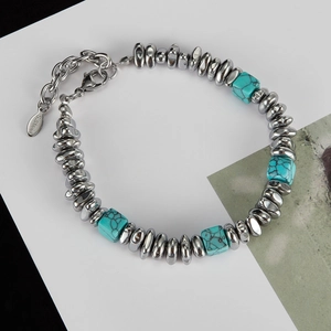 Detail of titanium steel bracelet with green volcanic stone beads and S.Steel tag