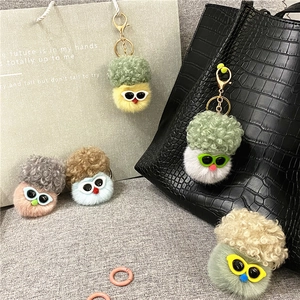 Cute cauliflower plush keychain with sunglasses hanging on a bag and stylish paper bag