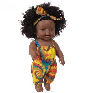 Close-up of African baby doll with black curly hair in a vibrant yellow tie-dye outfit
