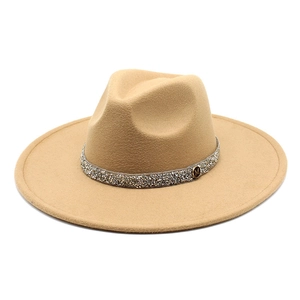Detail of camel wool fedora hat featuring rhinestone band and gold M letter metal plate