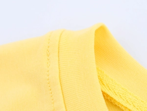 Close-up of yellow knit T-shirt collar showing ribbed texture and precise stitching detail