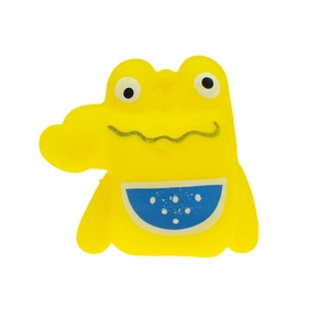 Macro detail of yellow cartoon crocodile finger puppet with blue dotted belly