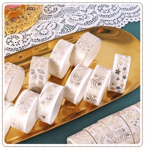 Detailed view of floral gold foil washi tape rolls arranged on a decorative golden tray