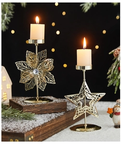 Detailed view of gold metal reindeer and snowflake candle holders on snowy wood base