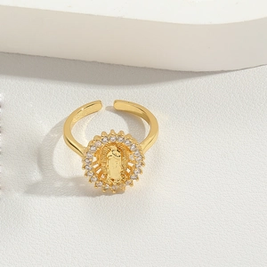 Macro detail of gold-plated religious bow ring featuring virgin mary and zircon stones