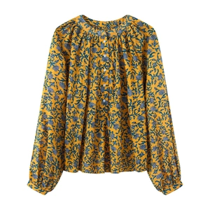 Detailansicht der gelben Blumenbluse mit plissiertem Ausschnitt und Laternenärmeln