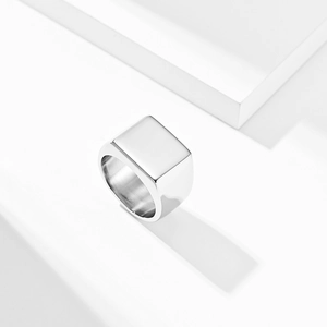 Macro detail of a polished stainless steel square signet ring with sharp geometric shadows