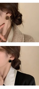 Close-up of French vintage square stud earrings in brown and black with gold edges