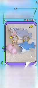 Close-up of cute cartoon shark and pig couple keychains with gold lobster clasps