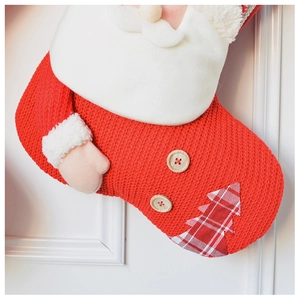 Detail of red knitted Christmas stocking with 3D Santa plush beard and wooden buttons
