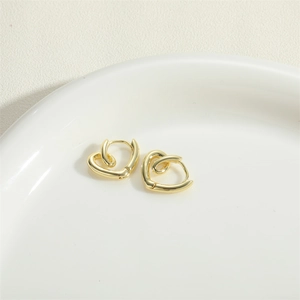 Minimalist gold heart-shaped hoop earrings presented on a white ceramic plate