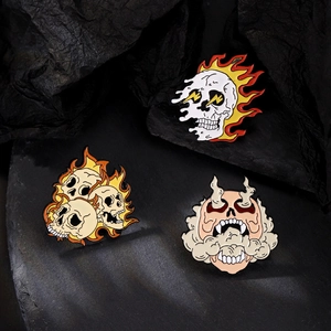 Detailed close-up of punk gothic skull and flame enamel pins on textured rock background