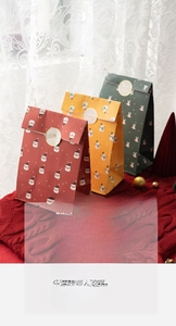 Three colorful Christmas gift paper bags with cartoon Santa and snowman patterns