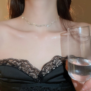 Close-up of silver wavy twist pendant necklace with rhinestones on female neck