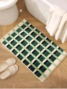 Détail du tapis de bain antidérapant à carreaux vert forêt et texture épaisse